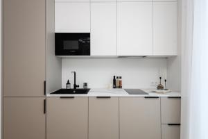 a white kitchen with white cabinets and a sink at Bob W Pärnu in Pärnu