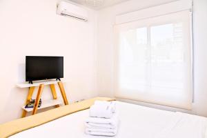 1 dormitorio con 1 cama, TV y toallas en Garage incluido! Terraza propia! Buenos Aires - Villa Urquiza en Buenos Aires