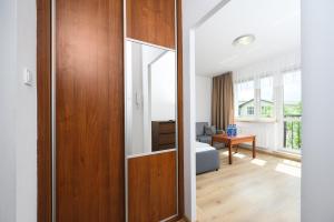 a room with a wooden door and a living room at Silver by OneApartments in Sopot