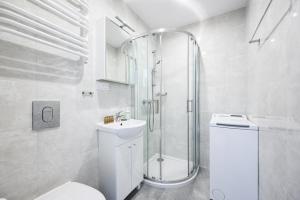 a bathroom with a shower and a toilet and a sink at Silver by OneApartments in Sopot