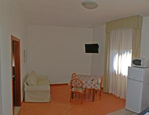 een woonkamer met een tafel, een bank en een stoel bij Residence Piccola Oasi in Vigonza