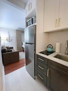 uma cozinha com um frigorífico de aço inoxidável e um sofá em 322 Cool Beach Studio em Hollywood