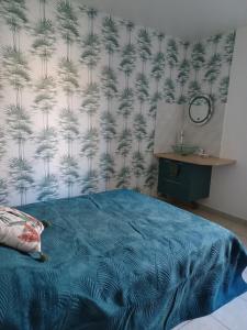 a bedroom with a blue bed with a wallpaper with pine needles at Chez Soizic et Patrick in Bords