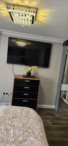 a bedroom with a dresser with a tv on the wall at Oxford Road Apartment in Reading