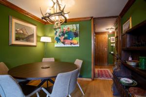 uma sala de jantar com uma mesa de madeira e paredes verdes em Maison 21 Cervinia cir n 0468 em Breuil-Cervinia