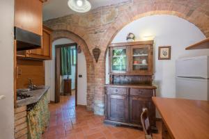 uma cozinha com uma parede de tijolos e um arco em Appartamento Aleatico em Montepulciano