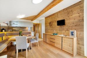 a kitchen and dining room with a wooden wall at Oberhof Apt Nagelstein in Larcher