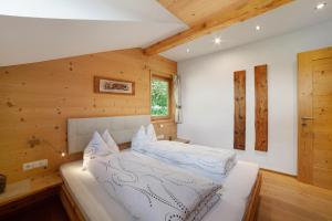 a bedroom with a large white bed with wooden walls at Oberhof Apt Nagelstein in Larcher