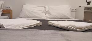 two white towels are sitting on a bed at Habtiar Guest House in Braga