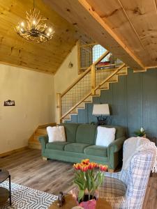 Jefferson的住宿－Blue Sky Cabin - Built in 2023 this 3 bed 2,5 bath home has gorgeous views，客厅设有绿色沙发和楼梯。