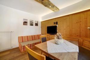 a living room with a table and a television at Oberhof Apt Ilmenspitz in Larcher