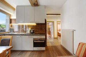 een keuken met witte kasten en een fornuis met oven bij Oberhof Apt Ilmenspitz in Larcher