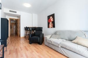 een woonkamer met een bank en een stoel bij Apartamento Postal in Fuengirola