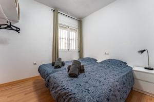 een slaapkamer met een blauw bed met handdoeken erop bij Apartamento Postal in Fuengirola +12 foto's