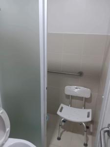 a bathroom with a shower and a toilet and a stool at 2 BR Loop Tower 1524 in Cagayan de Oro