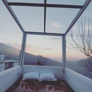 a room with a large window with a bed in it at Stargazing Glass Lodge Himachal Pradesh Thachi in Mandi