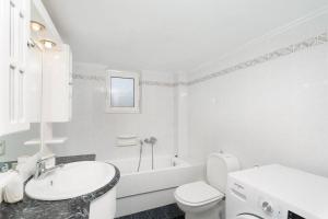 y baño blanco con lavabo, aseo y bañera. en Omnia Maisonette by A&D Properties, en Porto Rafti