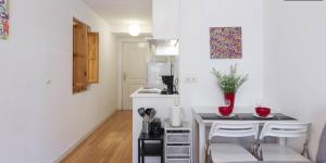 a kitchen with a table and two white chairs at My City Home - Piso increíble en paseo de extremadura in Madrid