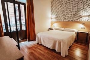 a bedroom with a bed and a large window at Atenas Granada in Granada