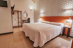 - une chambre avec un grand lit blanc dans l'établissement Atenas Granada, à Grenade