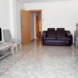 a living room with a leather couch and a table at Habitación Privada Cerca de Valencia En Vivienda Compartida in Paterna