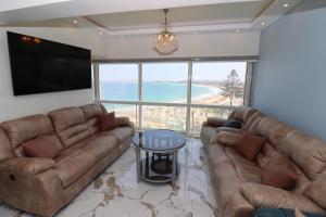 亞歷山大的住宿－Mamoura Private Beach, Exclusive Luxury & Comfort，客厅配有两张真皮沙发和一台平面电视