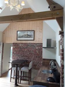 a kitchen with a table and a brick wall at Les Charmilles de Valencendre in La Calotterie