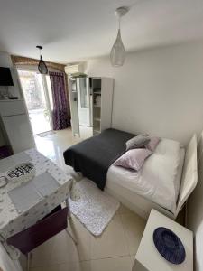 ein kleines Schlafzimmer mit einem Bett und einem Tisch in der Unterkunft Studio Apartment Klaric in Vis