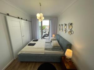um quarto com uma cama, um sofá e uma janela em Apartament 32 NOWA WIEJSKA Olecko Mazury Garbate em Olecko