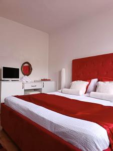 a bedroom with two beds with a red headboard at Nera-etwa Konjic 1 apartment in Konjic