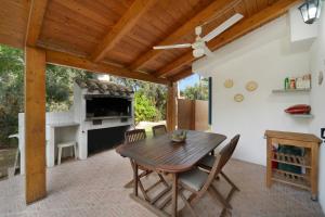 una sala da pranzo con tavolo in legno e camino di Villa Montali a Santa Margherita di Pula