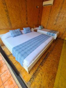 a bedroom with two beds with blue pillows at Hotel Momotus in Tuxtla Gutiérrez