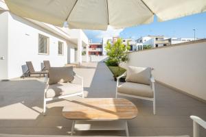 a patio with chairs and a table and an umbrella at La Tavernetta di Elisa in Calimera