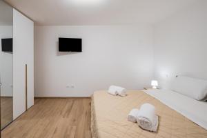 a white bedroom with a large bed with towels on it at La Tavernetta di Elisa in Calimera