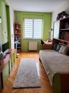 - une chambre avec des murs verts, un lit et un bureau dans l'établissement EXIT apartment Novi Sad 68m2, à Novi Sad