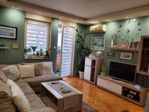 - un salon avec un canapé et une télévision dans l'établissement EXIT apartment Novi Sad 68m2, à Novi Sad