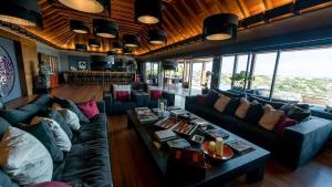 uma sala de estar com sofás, mesas e janelas em Villa Jade em Marigot