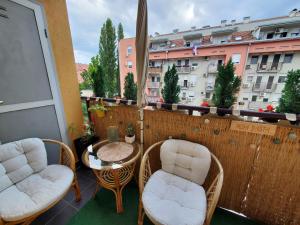 d'un balcon avec des chaises et une table. dans l'établissement EXIT apartment Novi Sad 68m2, à Novi Sad