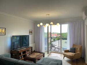 a living room with a couch and a flat screen tv at Apartament 32 NOWA WIEJSKA Olecko Mazury Garbate in Olecko