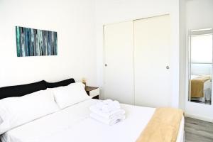 a white bedroom with a bed and a mirror at Garage incluido! Piso 10! Belgrano - Buenos Aires in Buenos Aires