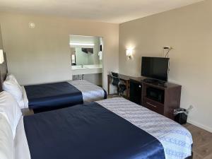 a hotel room with two beds and a flat screen tv at Oakwood Inn in Oakdale