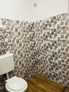 a bathroom with a toilet and a tiled wall at Zen Hostel in Cluj-Napoca