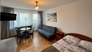 a bedroom with a bed and a table and a couch at Pokoje Gościnne U RYBAKA in Karwia