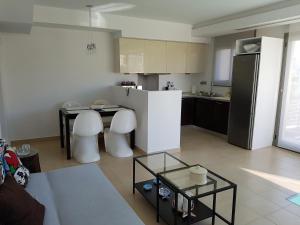 a small kitchen with a table and a refrigerator at RVG Rania House with pool in Porto Heli