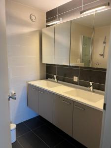 ein Bad mit einem Waschbecken und einem Spiegel in der Unterkunft Zeedijk Heist Hoekappartement Probitas G6 in Knokke-Heist