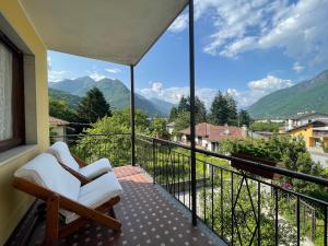 a balcony with white chairs and a view of mountains at [come a Casa] da Marina in Pieve Vergonte