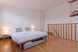 a bedroom with a bed with a clock on the wall at La Ciotat : Marius Appartement en duplex très cosy in La Ciotat