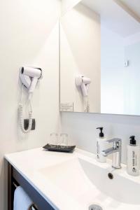 a white bathroom with a sink and a mirror at Mar Hotels Alcanada in Port d'Alcudia