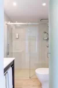 a bathroom with a shower and a toilet and a sink at Mar Hotels Alcanada in Port d'Alcudia