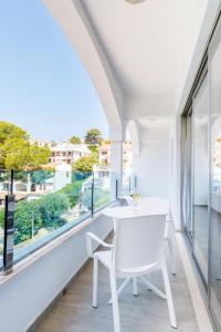 a white table and chairs in a room with windows at Mar Hotels Alcanada in Port d'Alcudia